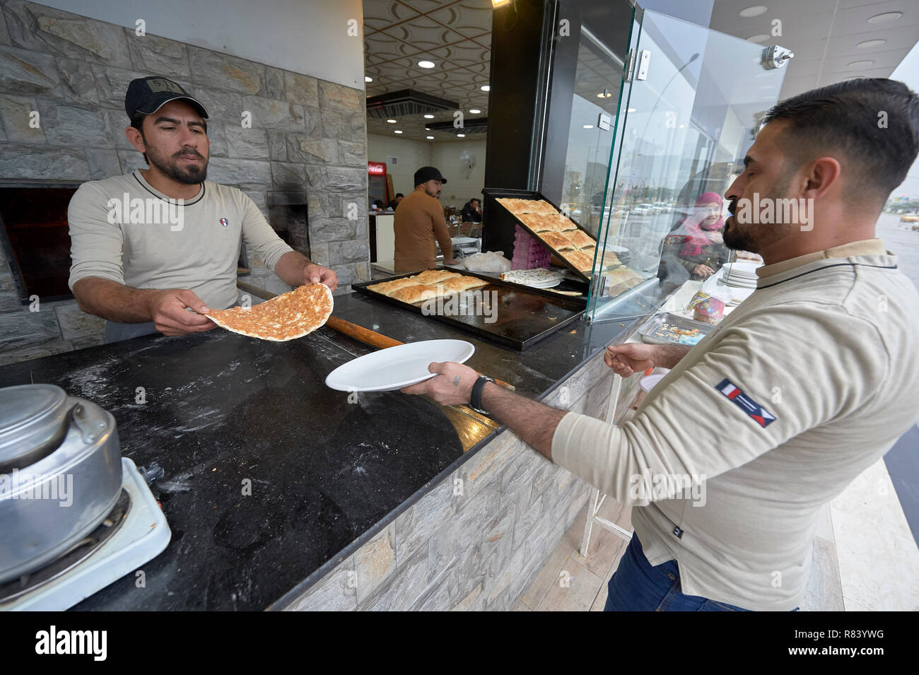 I lavoratori di preparare il cibo in un ristorante a Mosul, Iraq. La città fu devastata durante il 2017 Battaglia di Mosul, che ha portato alla sconfitta di Iside. Foto Stock