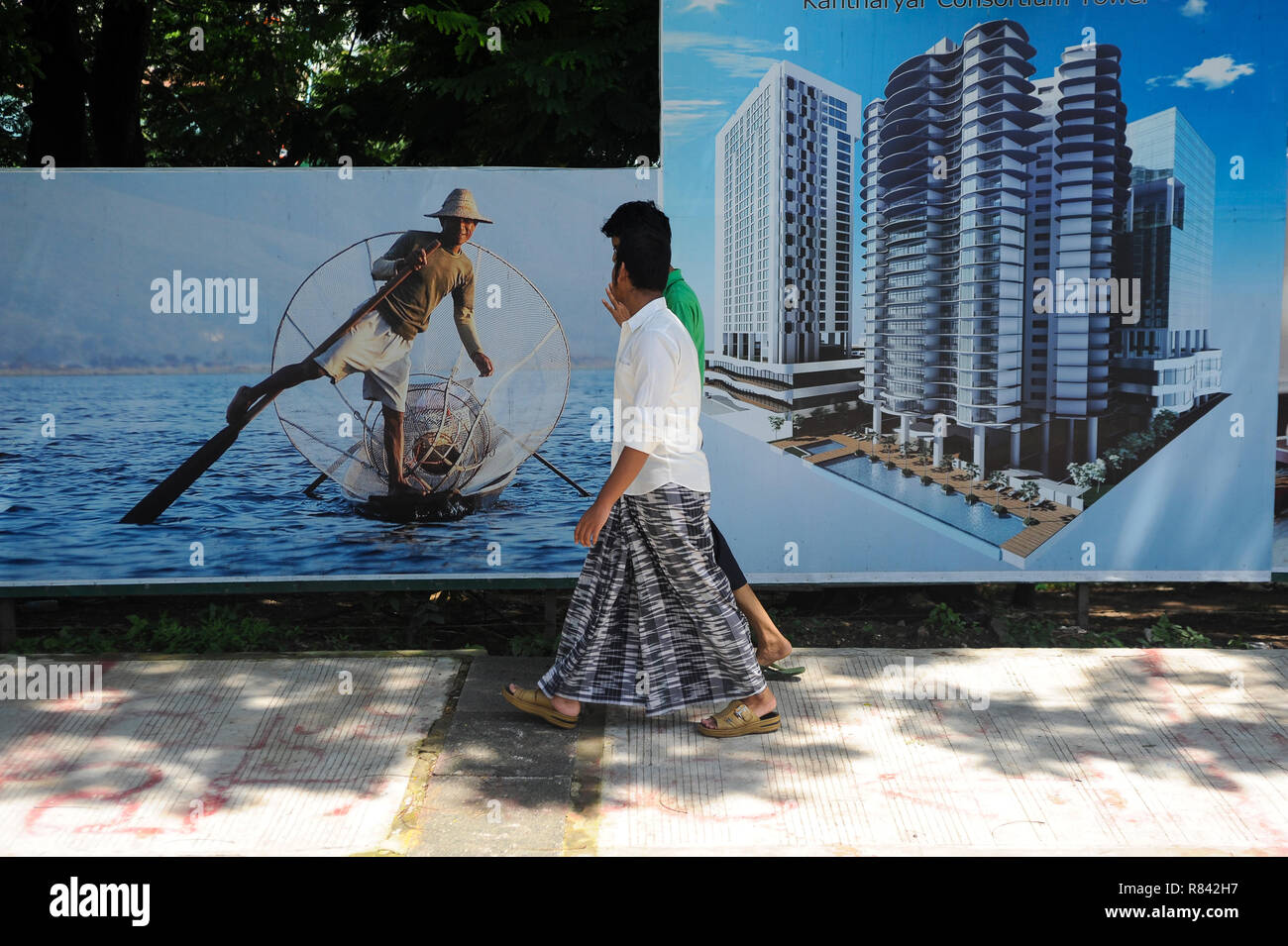 23.06.2014, Yangon, Myanmar, Asia - due uomini sono a piedi da cartelloni che pubblicizzano per nuovi edifici di appartamenti nel centro della ex capitale. Foto Stock