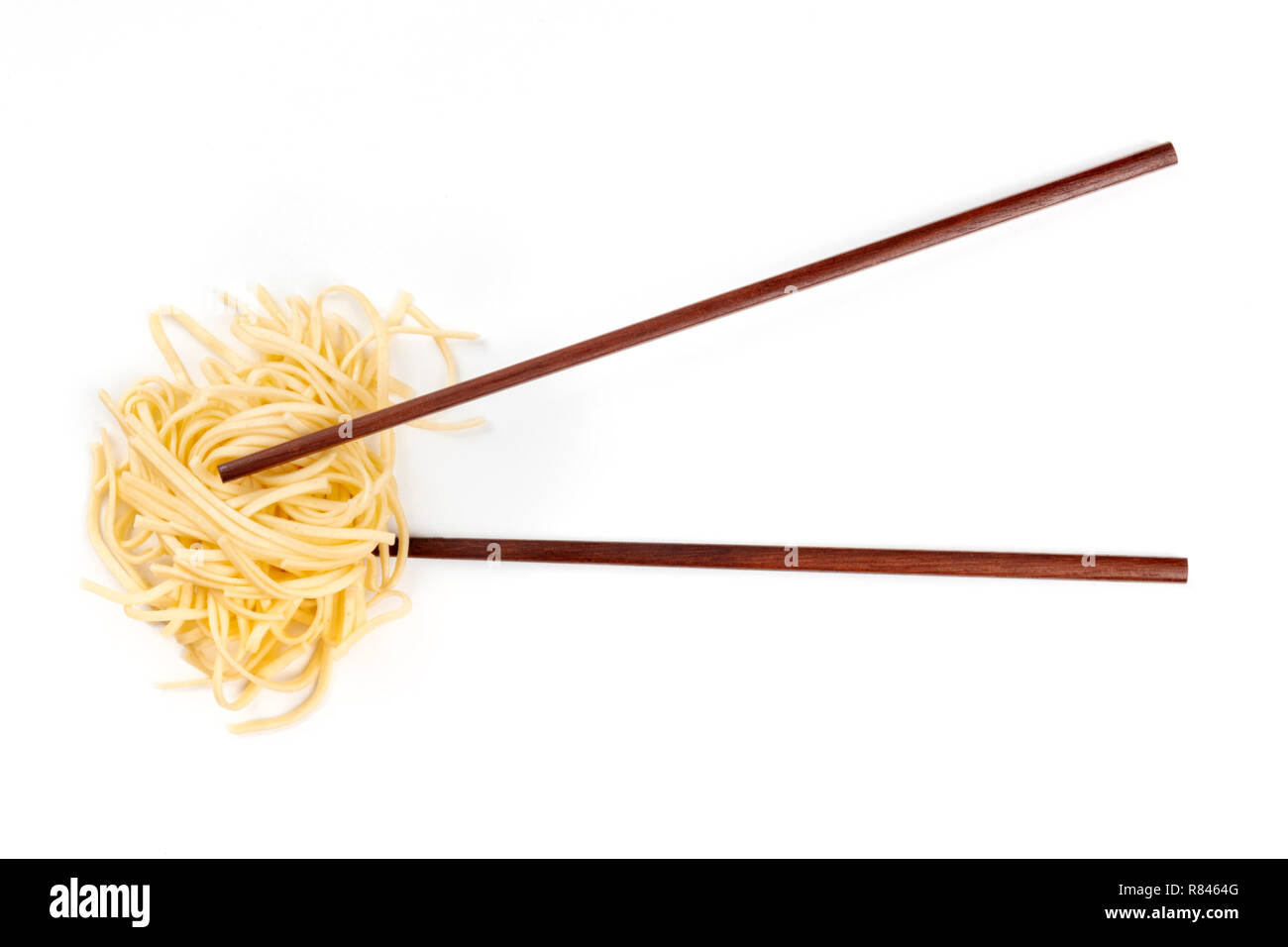 Una foto aerea di bastoncini con udon tagliatelle in una forma di nido, girato dalla parte superiore su uno sfondo bianco con un posto per il testo Foto Stock