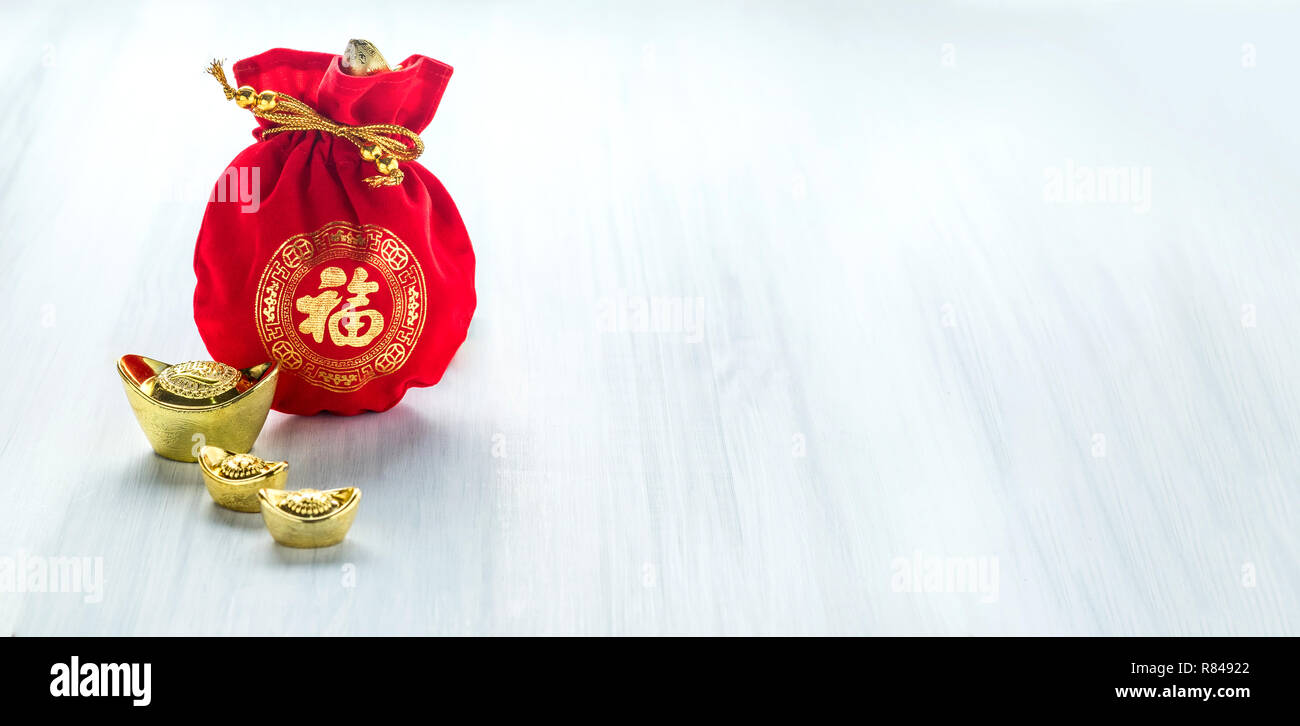 Anno Nuovo Cinese decoration,tessuto rosso o pacchetto ang pow con uno stile cinese pattern e lingotti d'oro su legno tavolo, lingua cinese significa Happine Foto Stock