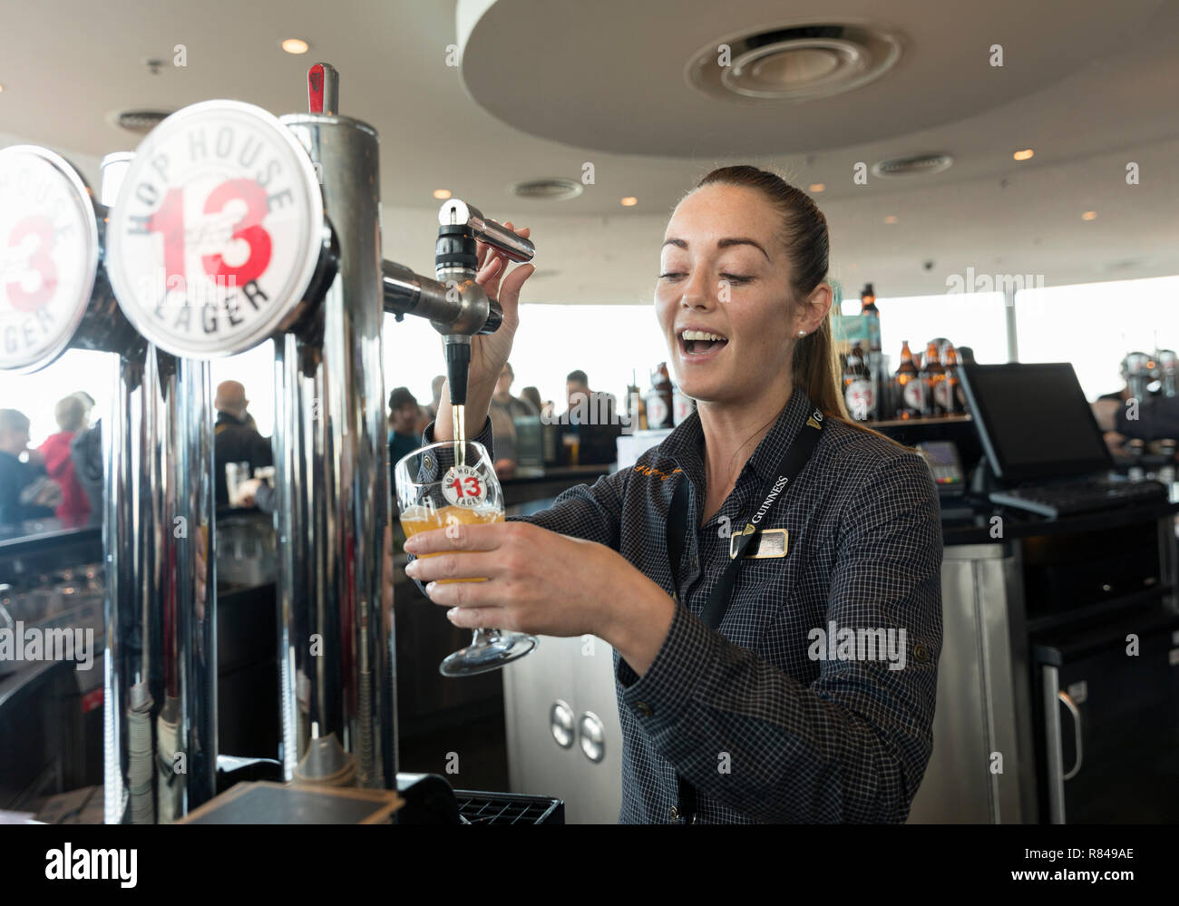 Irlanda, Dublino,Guinness Storehouse, bar Gravity, barman versare birra. Foto Stock
