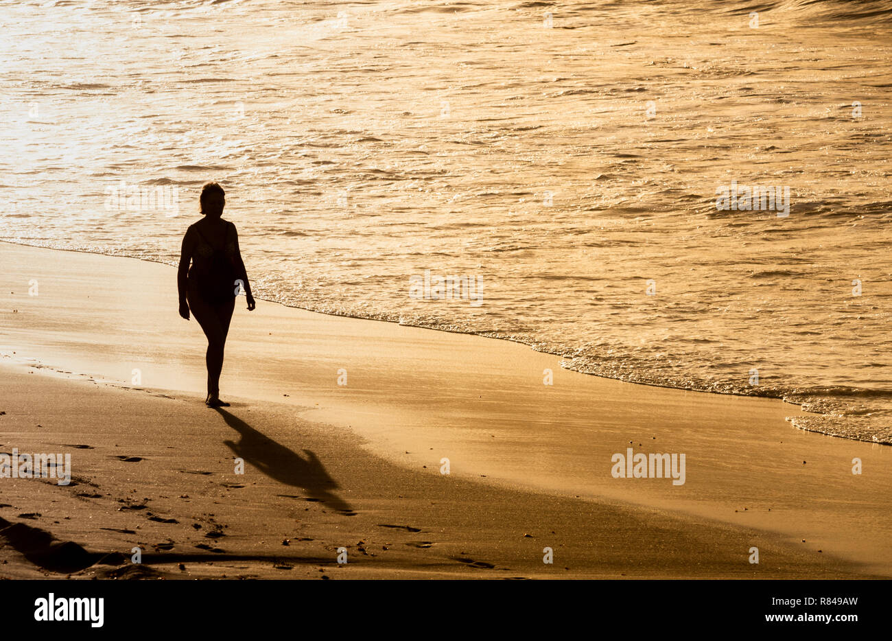 Donna matura camminando sulla spiaggia in Spagna Foto Stock