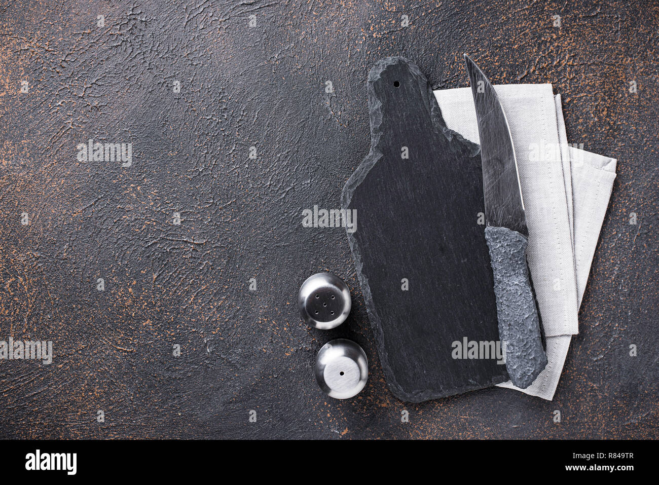 Sfondo culinario con spezie, coltello e tagliere Foto Stock