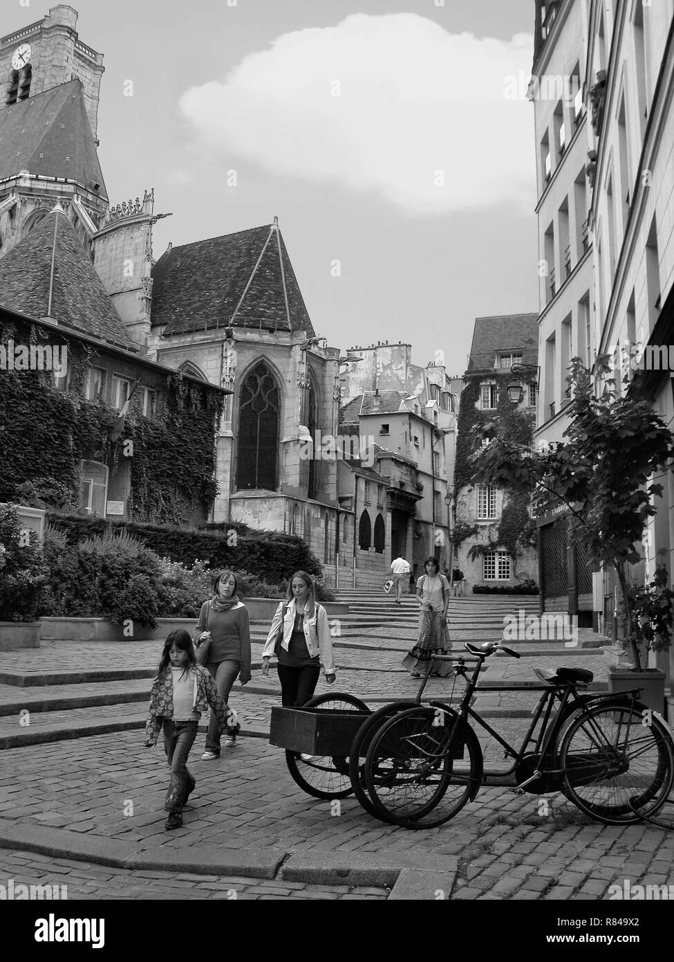 Vecchia bicicletta di consegna e i passanti su Rue des Barres, Marais, Paris, Francia. Versione in bianco e nero Foto Stock
