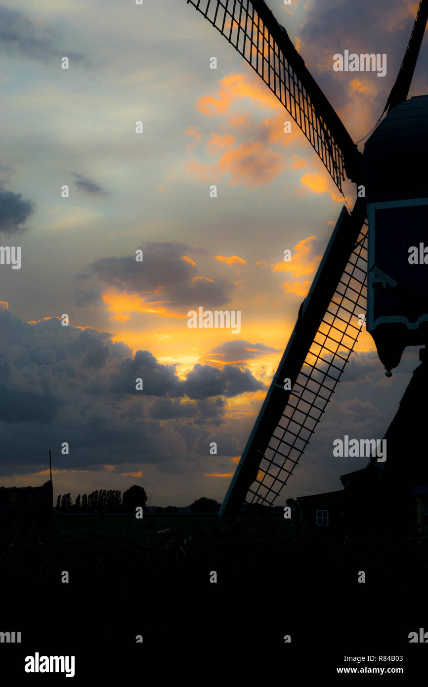 Silhouette di un tradizionale mulino a vento olandese contro un colorato del cielo della sera. Bellissimi colori nel cielo in una serata estiva oltre il paesaggio olandese. Foto Stock