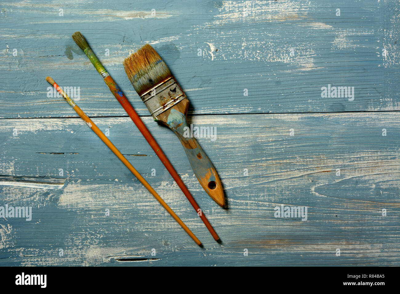 Sporco pennelli blu sul tavolo di legno - primo piano Foto Stock