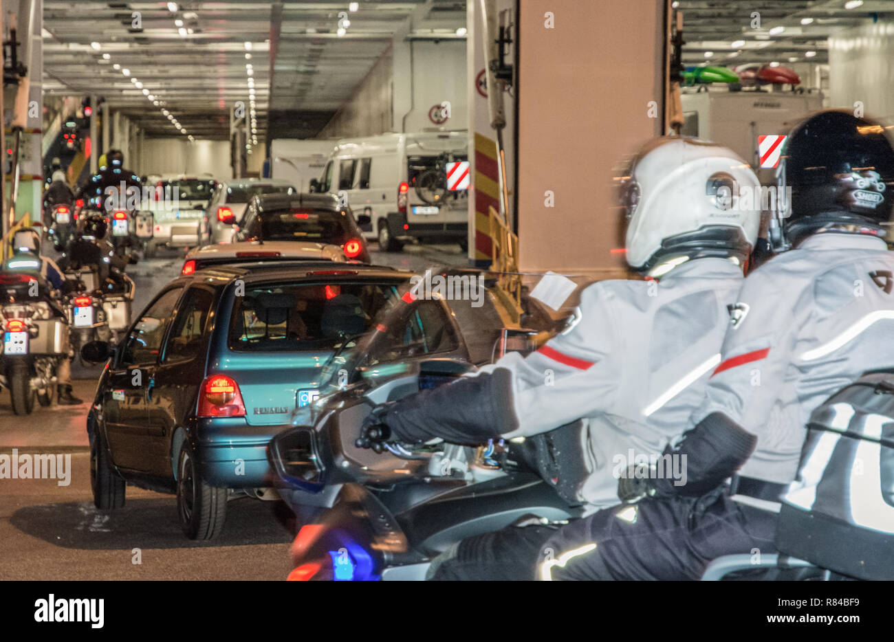 I veicoli e i motociclisti a bordo del Moby Line il traghetto per l'isola di Sardegna, in Italia, dal porto di Livorno. Foto Stock
