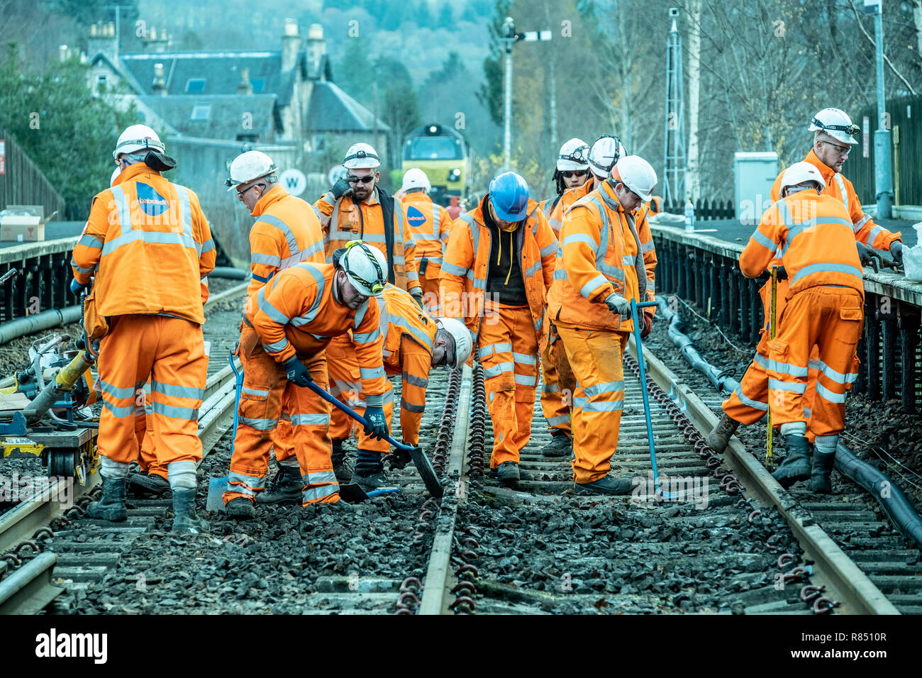 Lavoratori ferroviari recante nuova traccia, palline, punti di installazione e posa di cavi Foto Stock