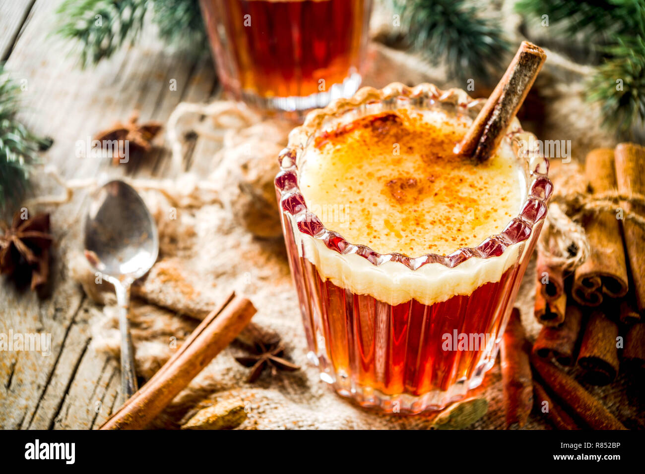 Vacanze invernali tradizionale bevanda calda in casa del rum imburrato con spezie, su un vecchio rustico sfondo di legno con albero di natale rami, spazio di copia Foto Stock