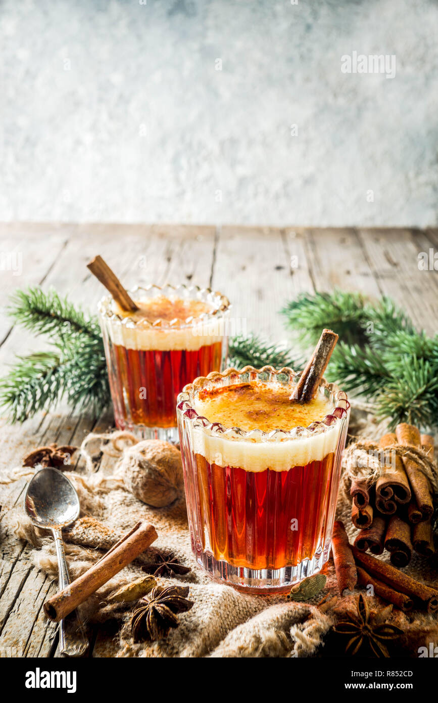 Vacanze invernali tradizionale bevanda calda in casa del rum imburrato con spezie, su un vecchio rustico sfondo di legno con albero di natale rami, spazio di copia Foto Stock