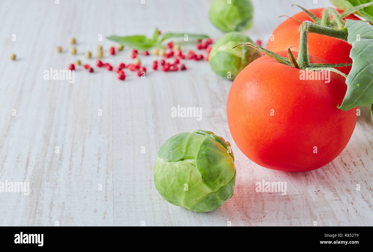 Fresche verdure di colore rosso sul tavolo di legno. Composizione di verdure, pomodoro, broccoli. In stile retrò. Foto Stock