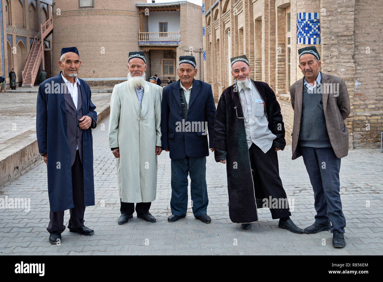 Khiva, Uzbekistan - 17 Aprile 2018: uomini anziani in tradizionali abiti uzbeko in posa vicino alla moschea di Itchan Kala - centro storico di Khiva Foto Stock