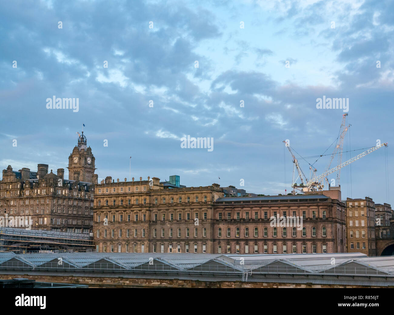 Edinburgh grand edifici in Alba d'inverno. Rocco Forte Balmoral Hotel con la torre dell orologio e la stazione di Waverley tetto di vetro, Scotland, Regno Unito Foto Stock