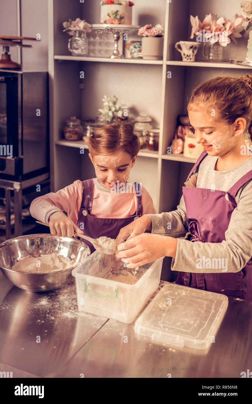 Ricetta della torta. Allegro bella bambini la miscelazione degli ingredienti durante il tentativo di creare una torta Foto Stock