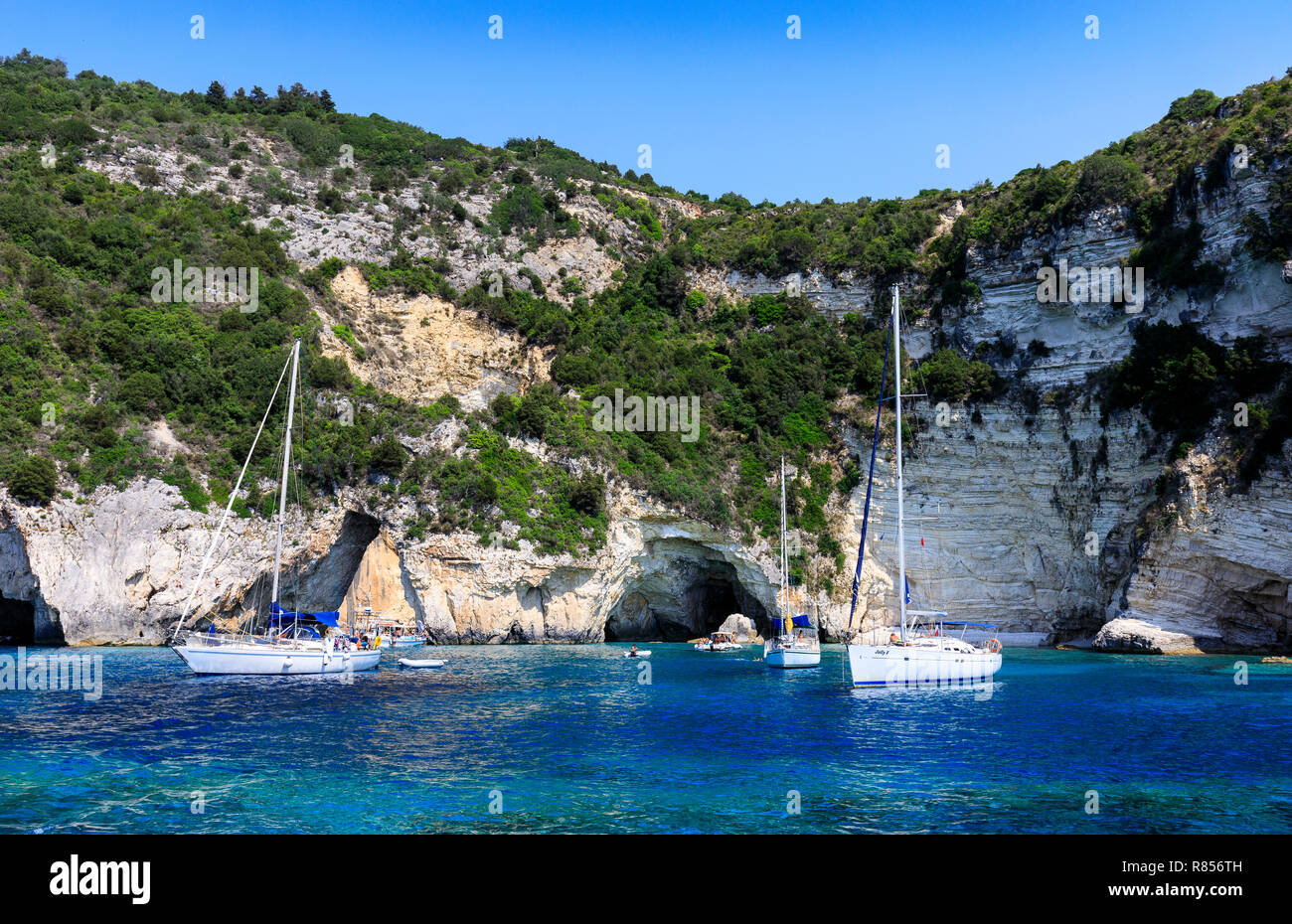 Barche a vela ormeggiata dalla west coast grotte, Paxos, Grecia Foto Stock