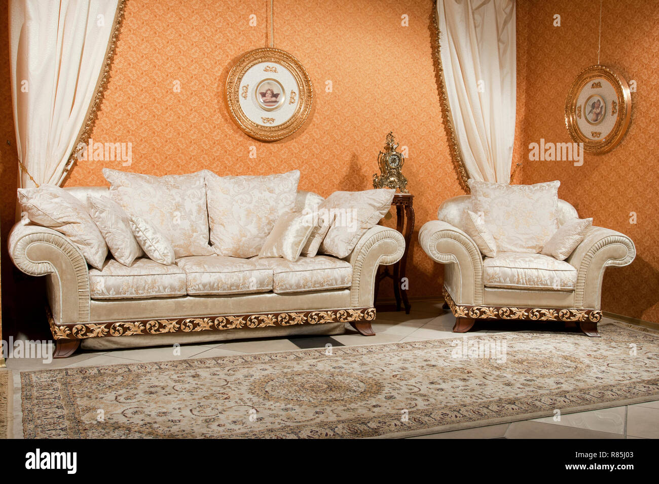 Interno vuoto soggiorno sfondo in colori caldi decorate con classico arredamento lussuoso divano e poltrona Foto Stock