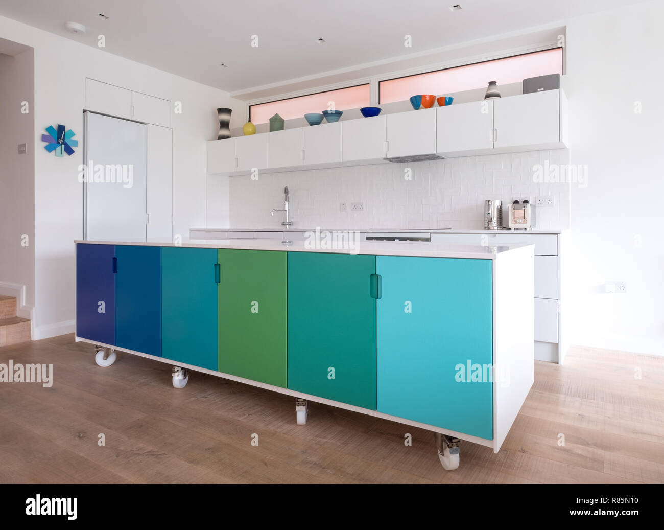 Progettati in modo personalizzato Isola della cucina nella cucina a pianta aperta, industriale su ruote piroettanti, design retrò dipinte di blu e verde ombre di colori. Foto Stock