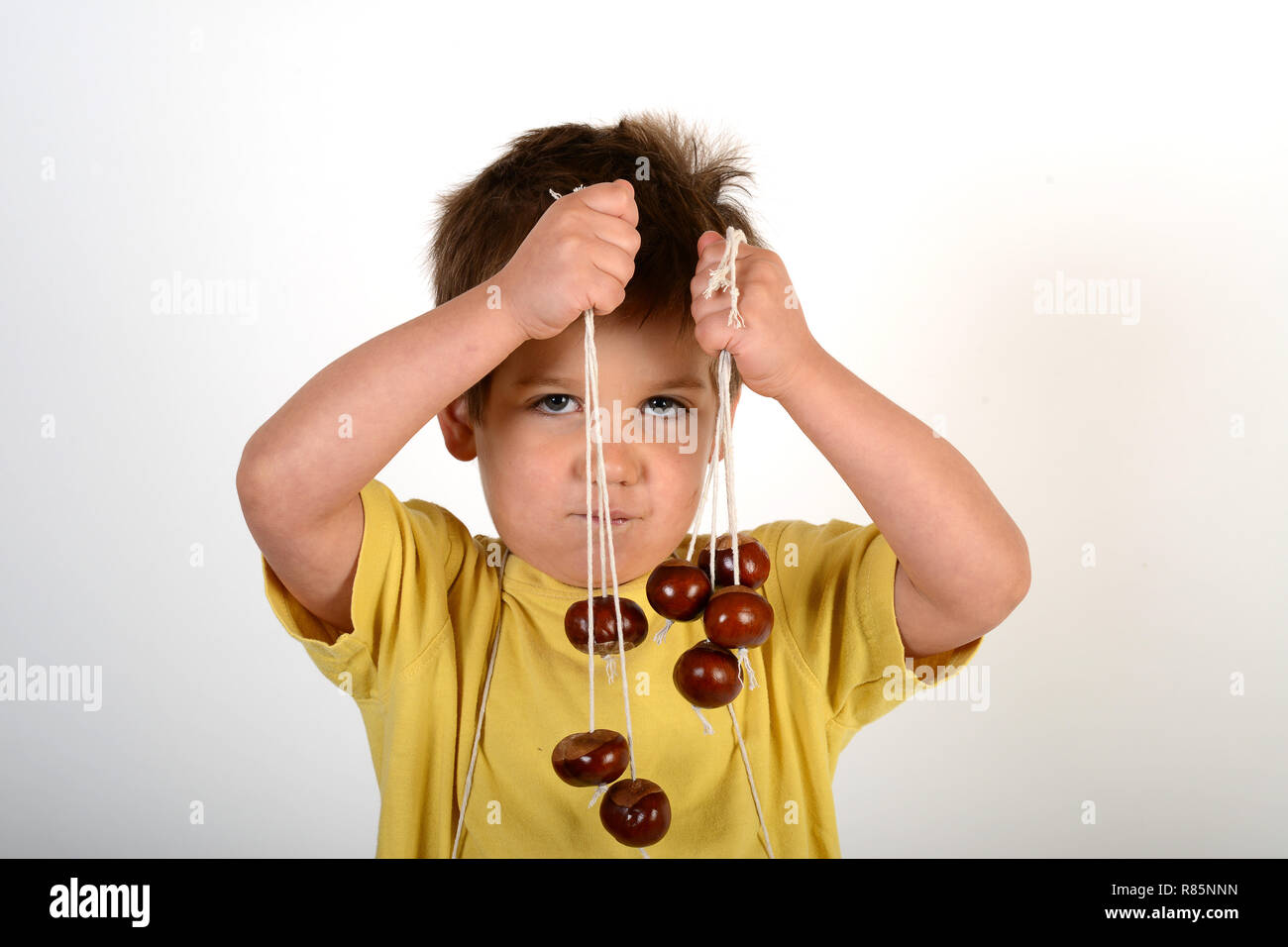 Un giovane bambino ragazzo con conkers Foto Stock