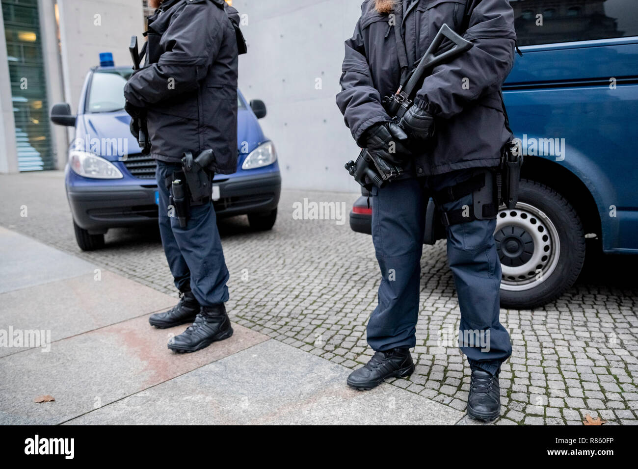 Berlino, Germania. Xiii Dec, 2018. Due funzionari di giustizia con mitra stare accanto a due veicoli all'Paul-Löbe-Haus. Giovedì, membri del Bundestag ha contestato un marocchino, che sta per essere deportato, circa un attacco sulla Breitscheidplatz a Berlino in un non-pubblica riunione del comitato. L'uomo aveva vissuto in Dortmund con l'assassino Amri per qualche tempo ed è attualmente in carcere per pericolosi assalto. Credito: Christoph Soeder/dpa/Alamy Live News Foto Stock