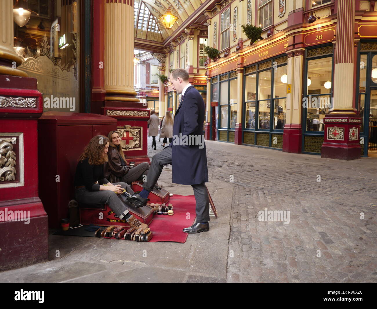 Sciuscià, lustrascarpe, lucidascarpe, onorevoli colleghe nel mercato Leadenhall Londra, polacco un businessmans scarpe Foto Stock