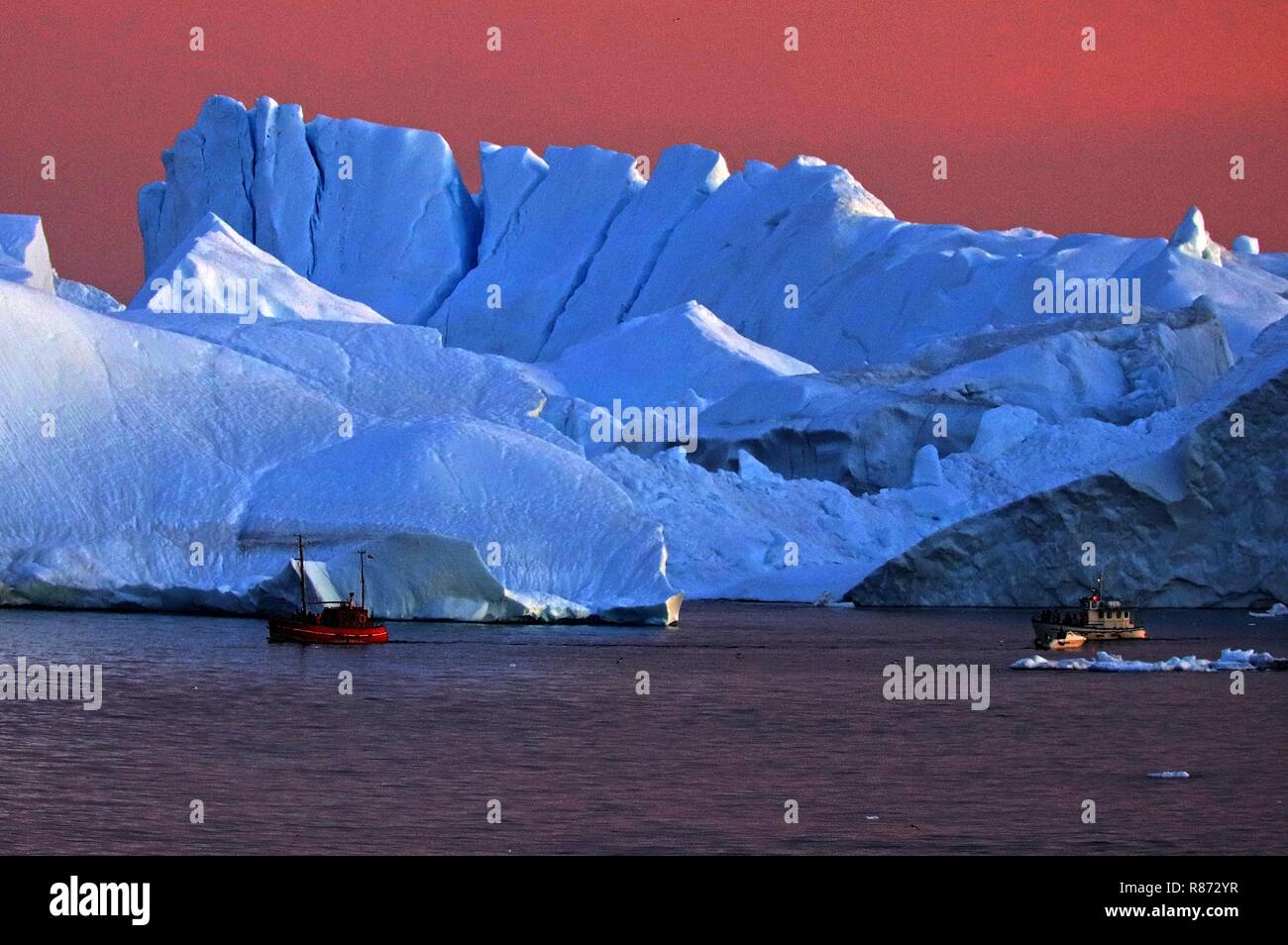 Ilulissat Eisberge im Abendrot mit Ausflugsboot Foto Stock