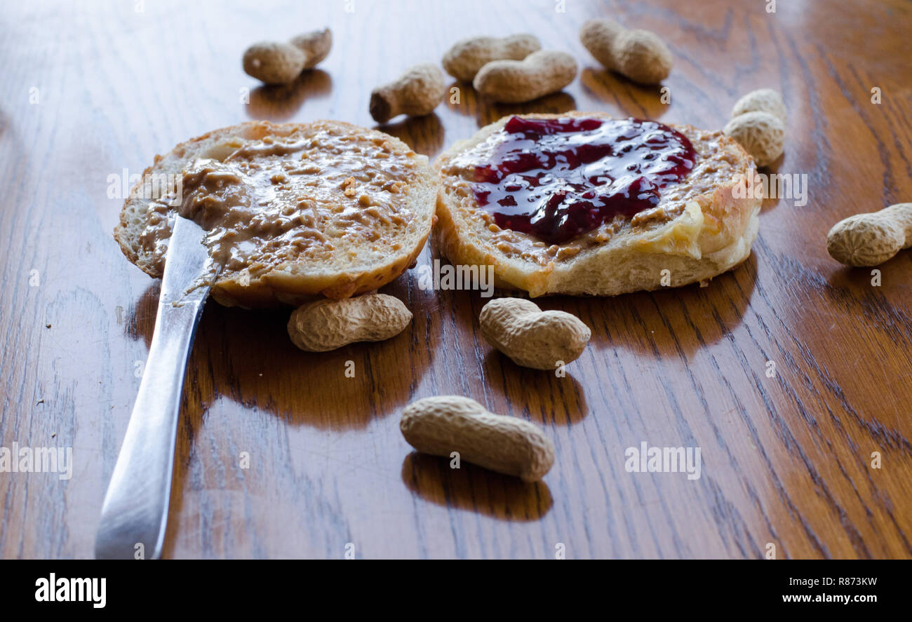 Burro di arachidi e jelly sandwich con tutta le arachidi sparsi sul tavolo Foto Stock