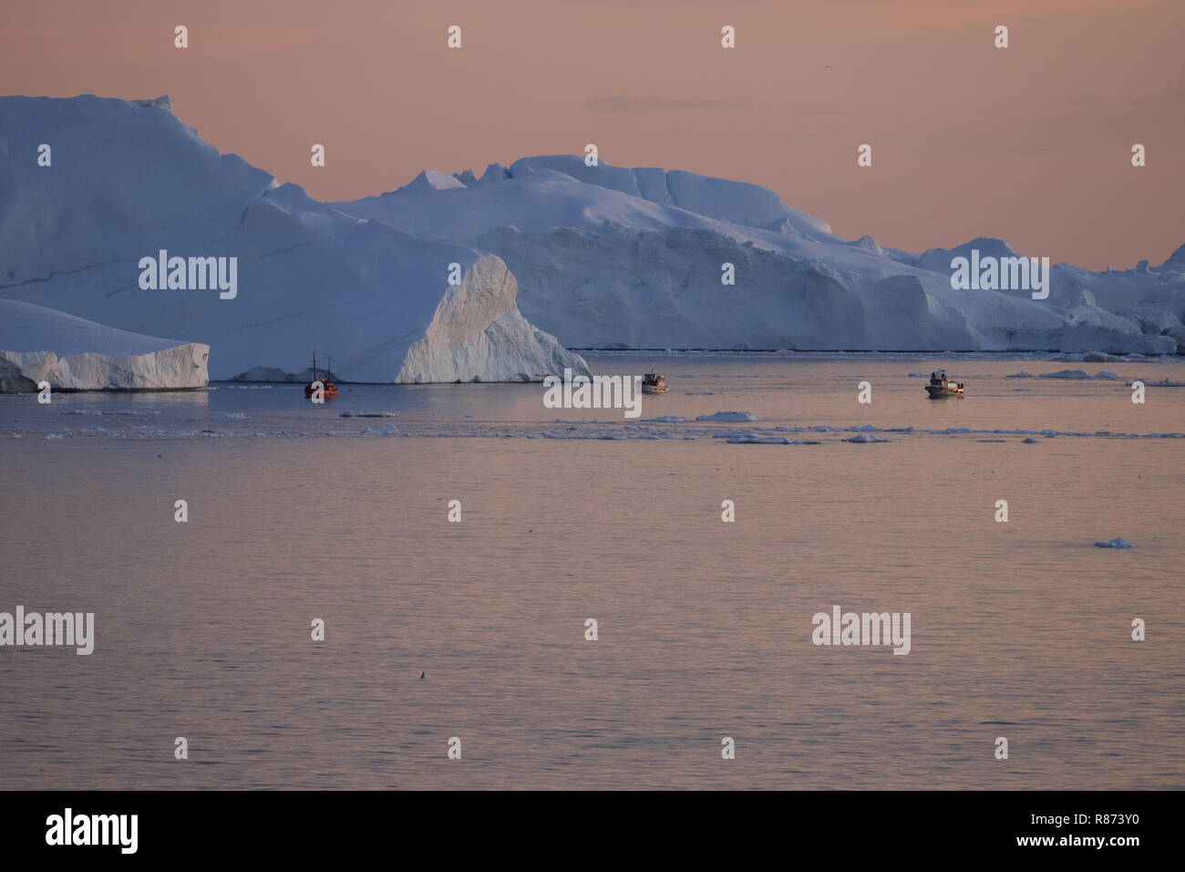 Ilulissat Tourist Nature Eisberge am Abend mit Ausflugsbooten Foto Stock