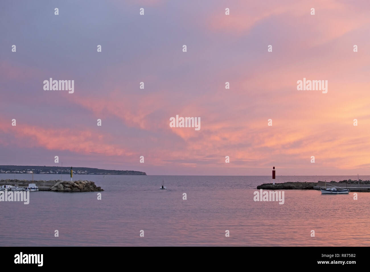 MALLORCA, Spagna - 24 novembre 2018: rosa polverulento tramonto in inverno sci e oceano paesaggio con Pier e barche su Novembre 24, 2018 a Mallorca, Spagna. Foto Stock