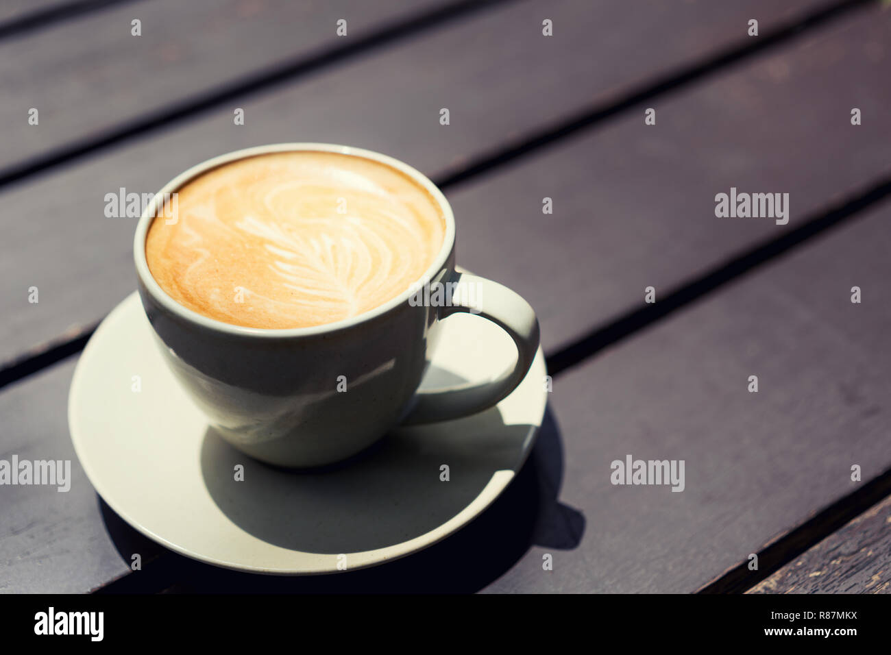 Arte a caldo Latte caffè in una tazza sul tavolo di legno nella caffetteria. Foto Stock