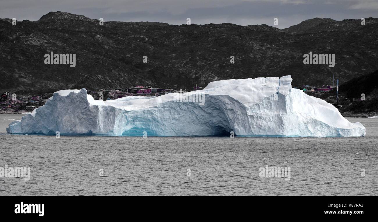 Grönland Disko Bucht: Eisberg mit Gletschertor. Im Hintergrund Ilulissat. Foto Stock