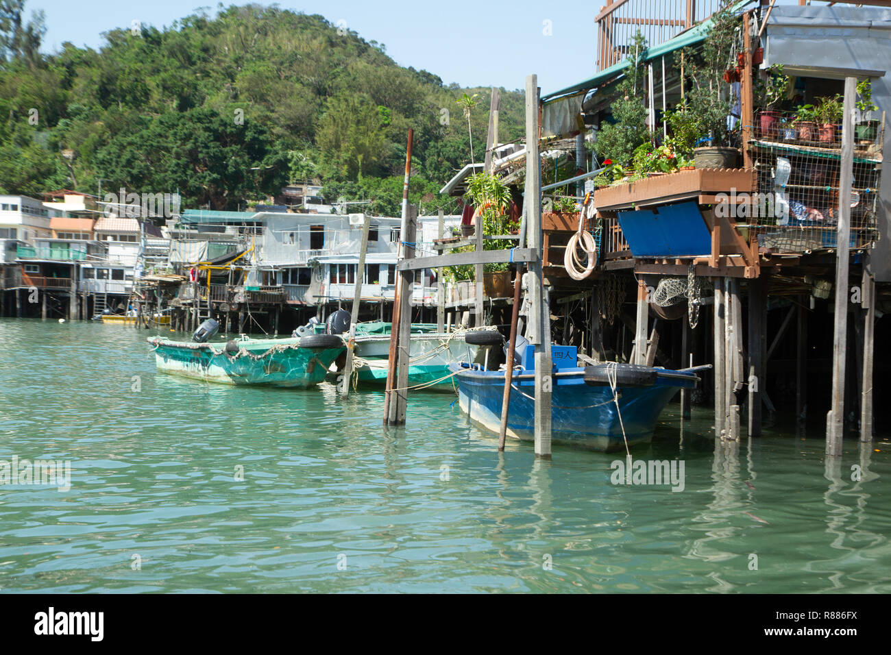 Colore, foto di paesaggi nel villaggio di pescatori Tai O sull'Isola di Lantau, Hong Kong, Cina. Barche floating accanto a palafitte, colline in background. Foto Stock Colore, foto di paesaggi nel villaggio di pescatori Tai O sull'Isola di Lantau, Hong Kong, Cina. Barche floating accanto a palafitte, colline in background. Foto Stock