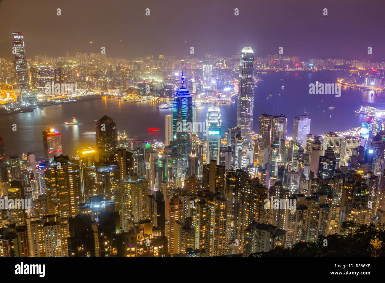 Skyline di Hong Kong di notte come si vede dal Victoria Peak. I grattacieli illuminati in primo piano, porto di Hong Kong in background. Foto Stock Skyline di Hong Kong di notte come si vede dal Victoria Peak. I grattacieli illuminati in primo piano, porto di Hong Kong in background. Foto Stock