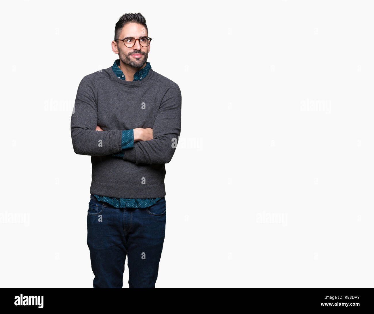 Giovane uomo bello con gli occhiali su sfondo isolato sorridente cercando lato e lo sguardo lontano pensando. Foto Stock