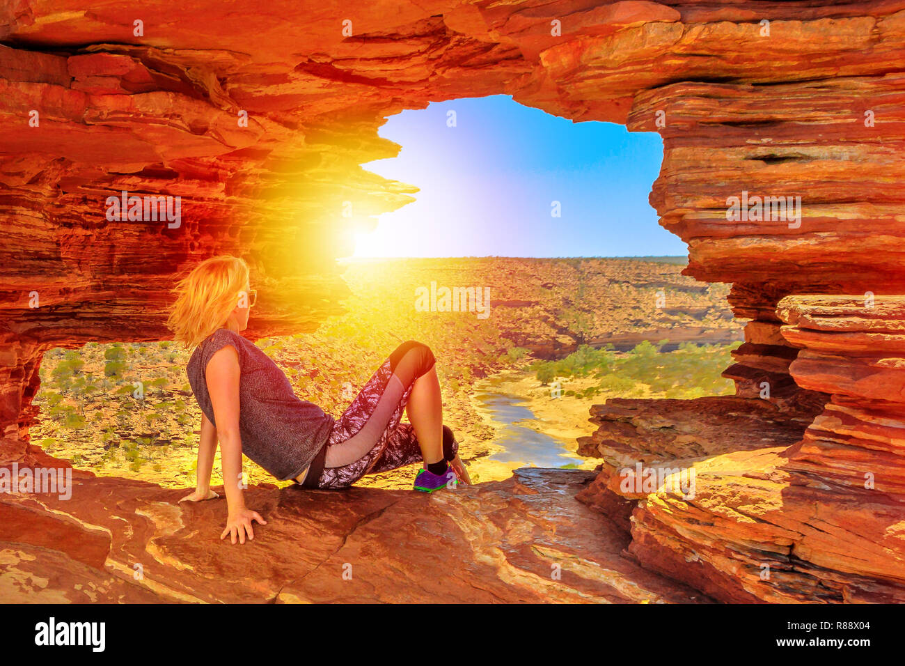 Donna sulla roccia arch della natura di finestra, al tramonto sul fiume Murchison in Kalbarri National Park, Australia occidentale. Viaggi Australia outback. Foto Stock