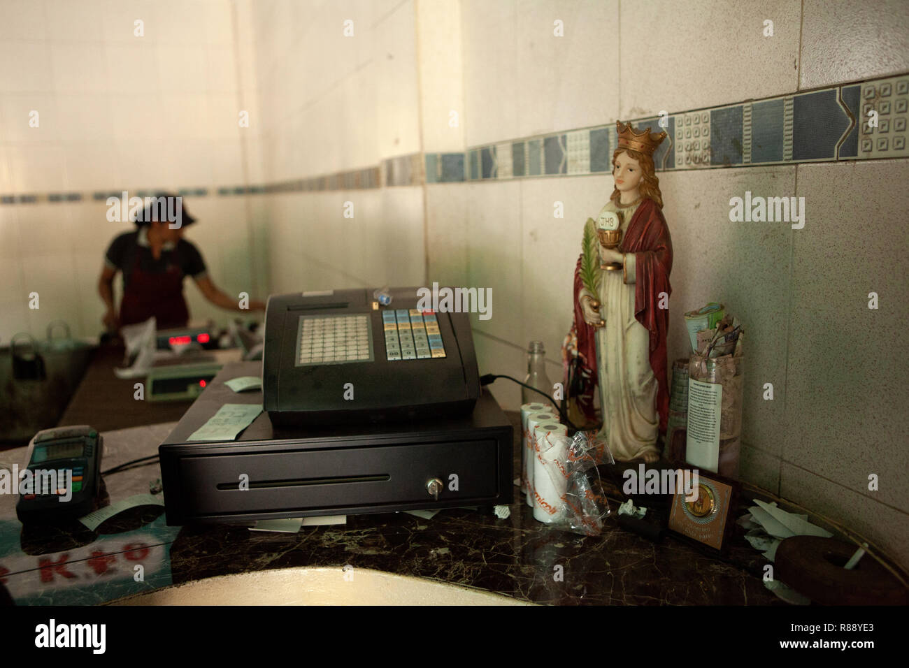 Statua religiosa accanto al registratore di cassa su shop cassa, Merida, Venezuela, Sud America Foto Stock