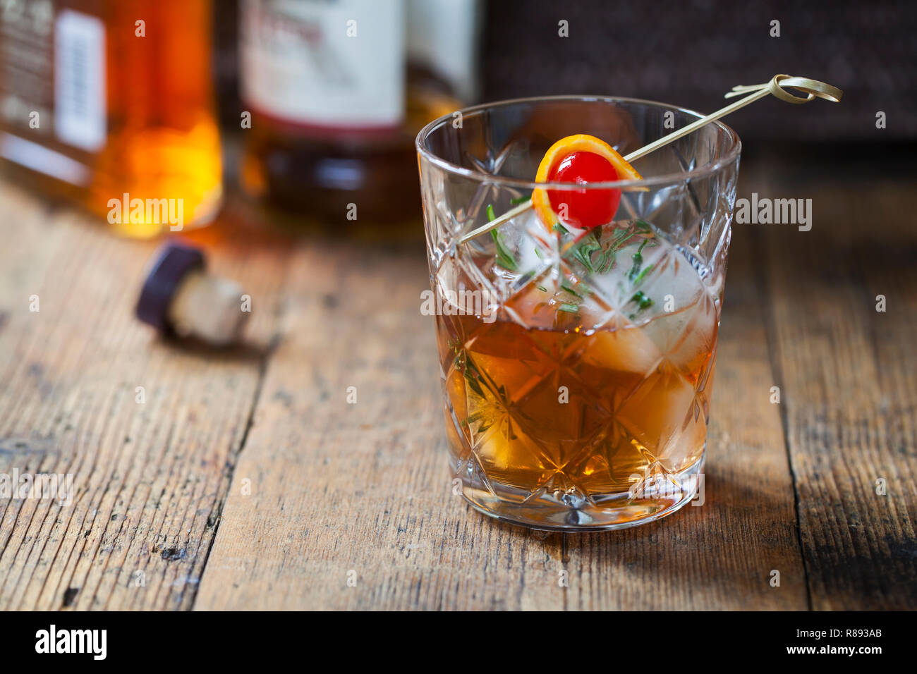 In vecchio stile, drink di whiskey con rosmarino cubetti di ghiaccio Foto Stock