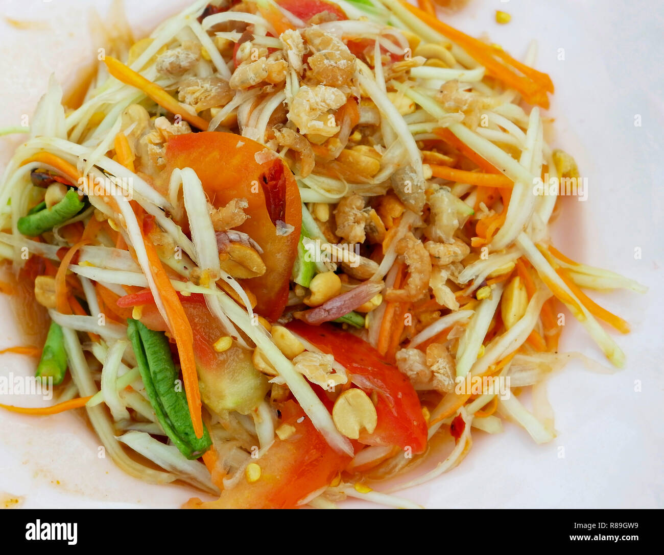 Il cibo in stile thai insalata di papaia / close up insalata di papaya sulla piastra calda e piccante con arachidi gamberi secchi cantiere lunga di fagioli e pomodoro Foto Stock