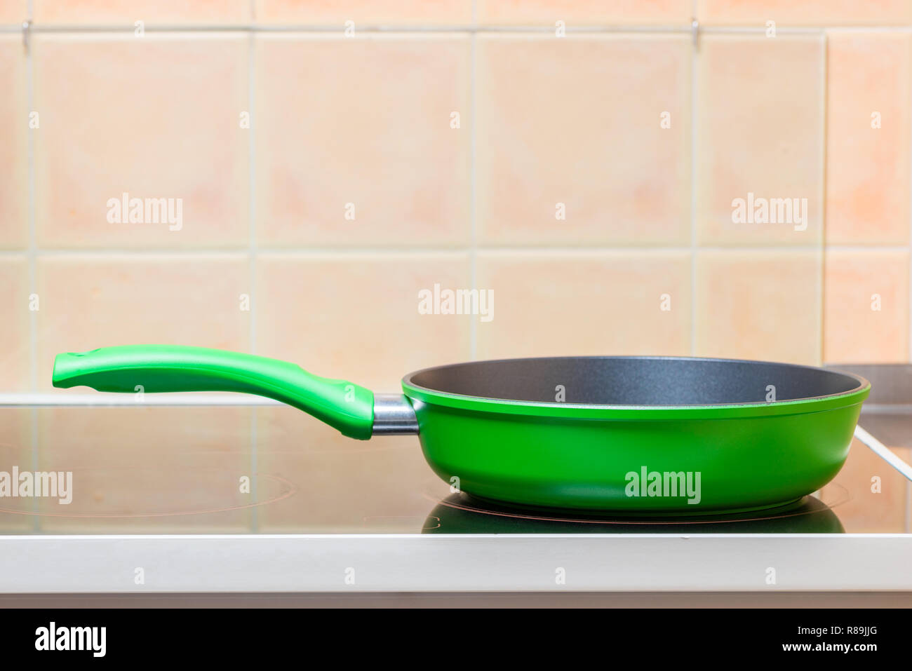 Green padella closeup sul vetro stufa in ceramica Foto Stock