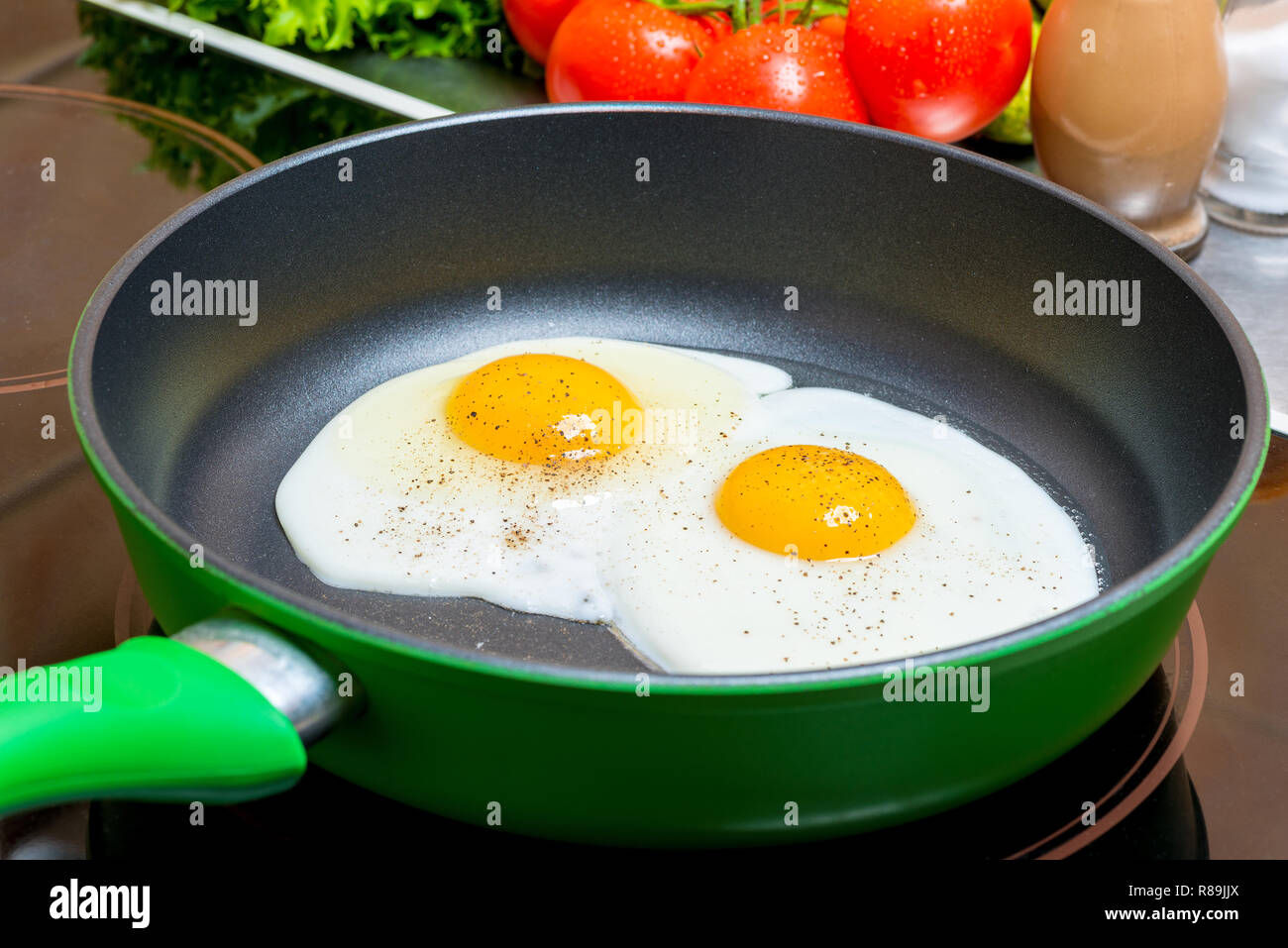 Uova fritte in padella fritto su una piastra elettrica da vicino Foto Stock