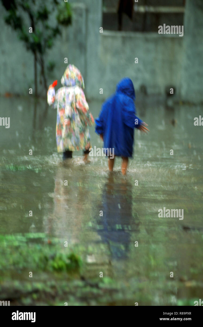 I bambini a piedi in acqua di monsone sulla strada, kutch, Gujarat, India il sig.NR.342 Foto Stock