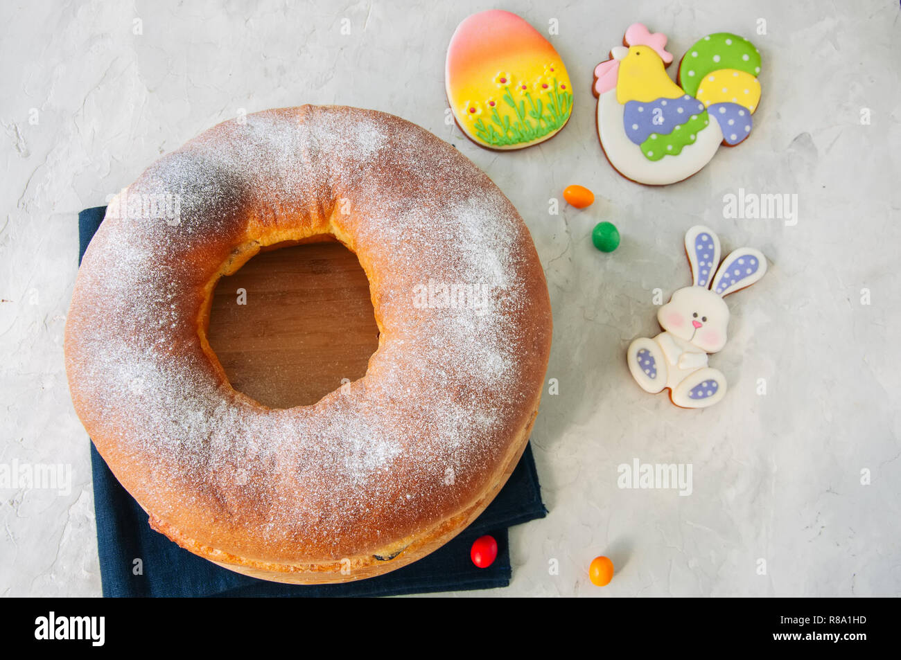 Reindling - Austriaco o Tedesco festosa sapore di lievito il lievito per la Pasqua. L'anello torta servita su un piatto di legno su una pietra bianca dello sfondo. Foto Stock