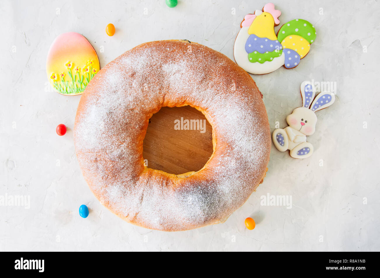 Reindling - Austriaco o Tedesco festosa sapore di lievito il lievito per la Pasqua. L'anello torta servita su un piatto di legno su una pietra bianca dello sfondo. Foto Stock
