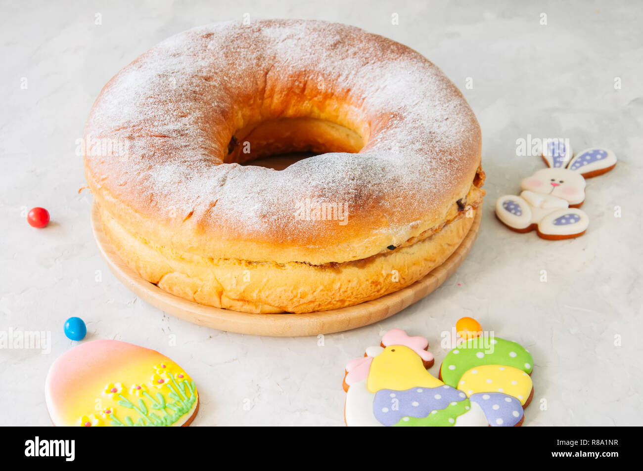 Reindling - Austriaco o Tedesco festosa sapore di lievito il lievito per la Pasqua. L'anello torta servita su un piatto di legno su una pietra bianca dello sfondo. Foto Stock