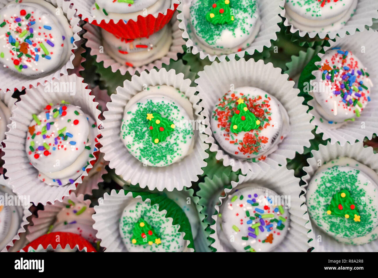 Il cioccolato bianco immerso cookie decorato e confezionato per Natale, con un pizzico di zucchero e jimmies Foto Stock