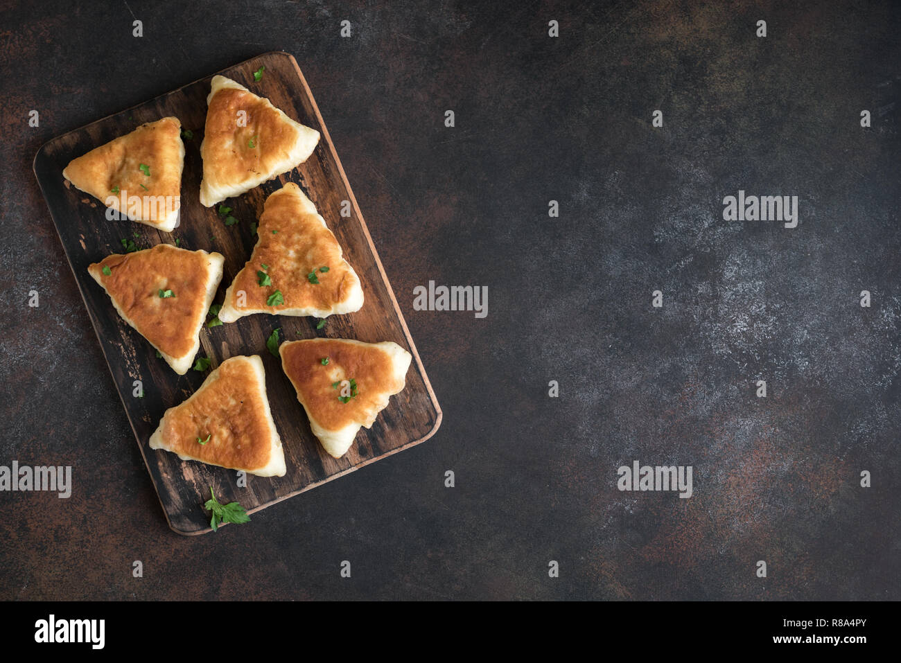 Fritte pasticci di carne, samsa, samosas, echpochmak - Le carni tradizionali torte ripiene o torte vegetariane su sfondo rustico, copia dello spazio. Foto Stock