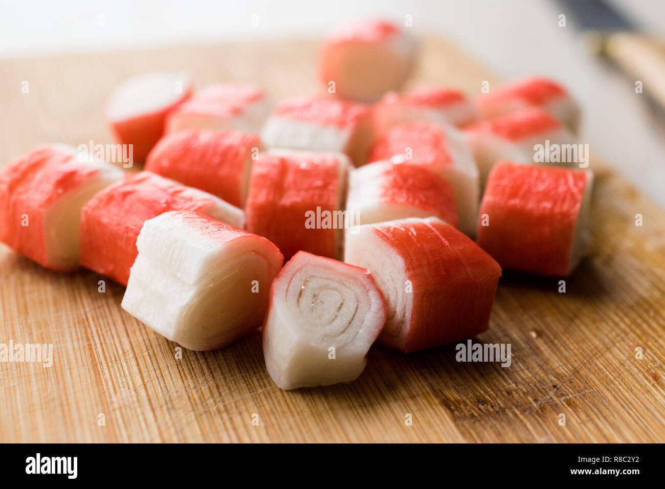 Fresco affettato Crab Stick fette di surimi sulla tavola di legno. Pronto a mangiare. Fast Food. Foto Stock