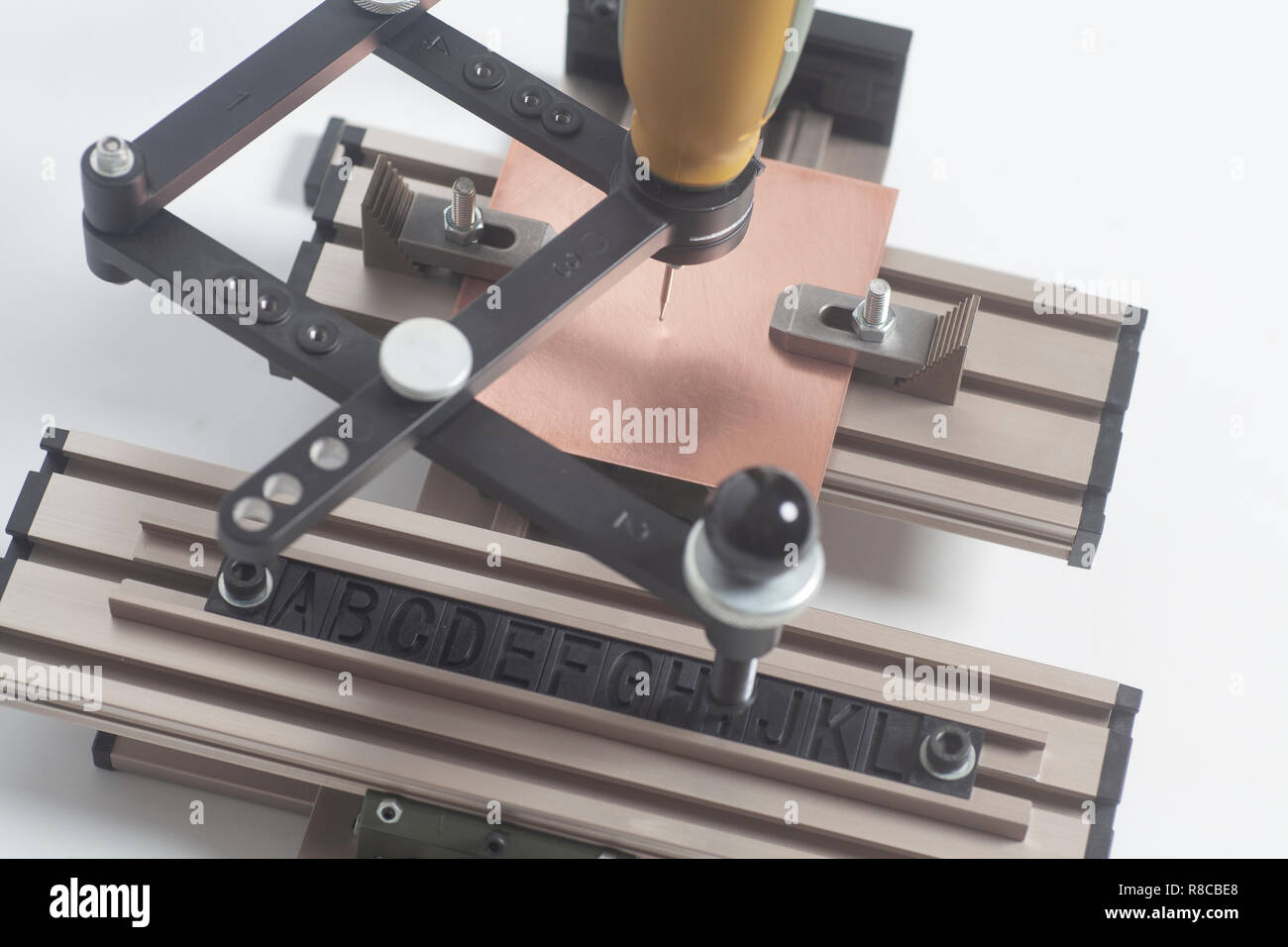 Dispositivo di incisione con pantografo a CNC con incisore alfabeto di stampa in rilievo su uno sfondo bianco Foto Stock
