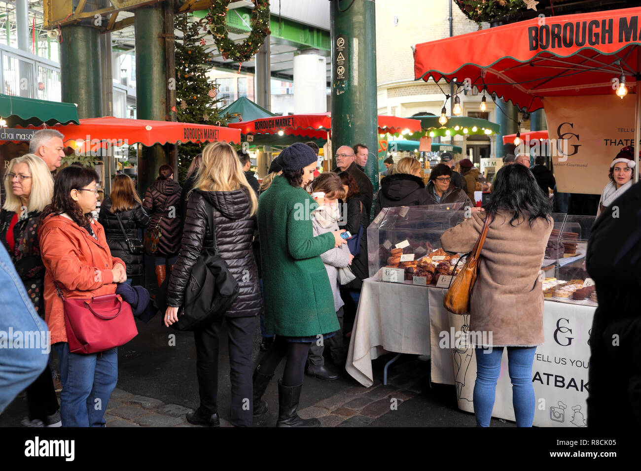 La folla di persone che guardano bancarelle prodotti alimentari all'interno di Borough Market al tempo di Natale a Southwark, Londra Sud UK KATHY DEWITT Foto Stock