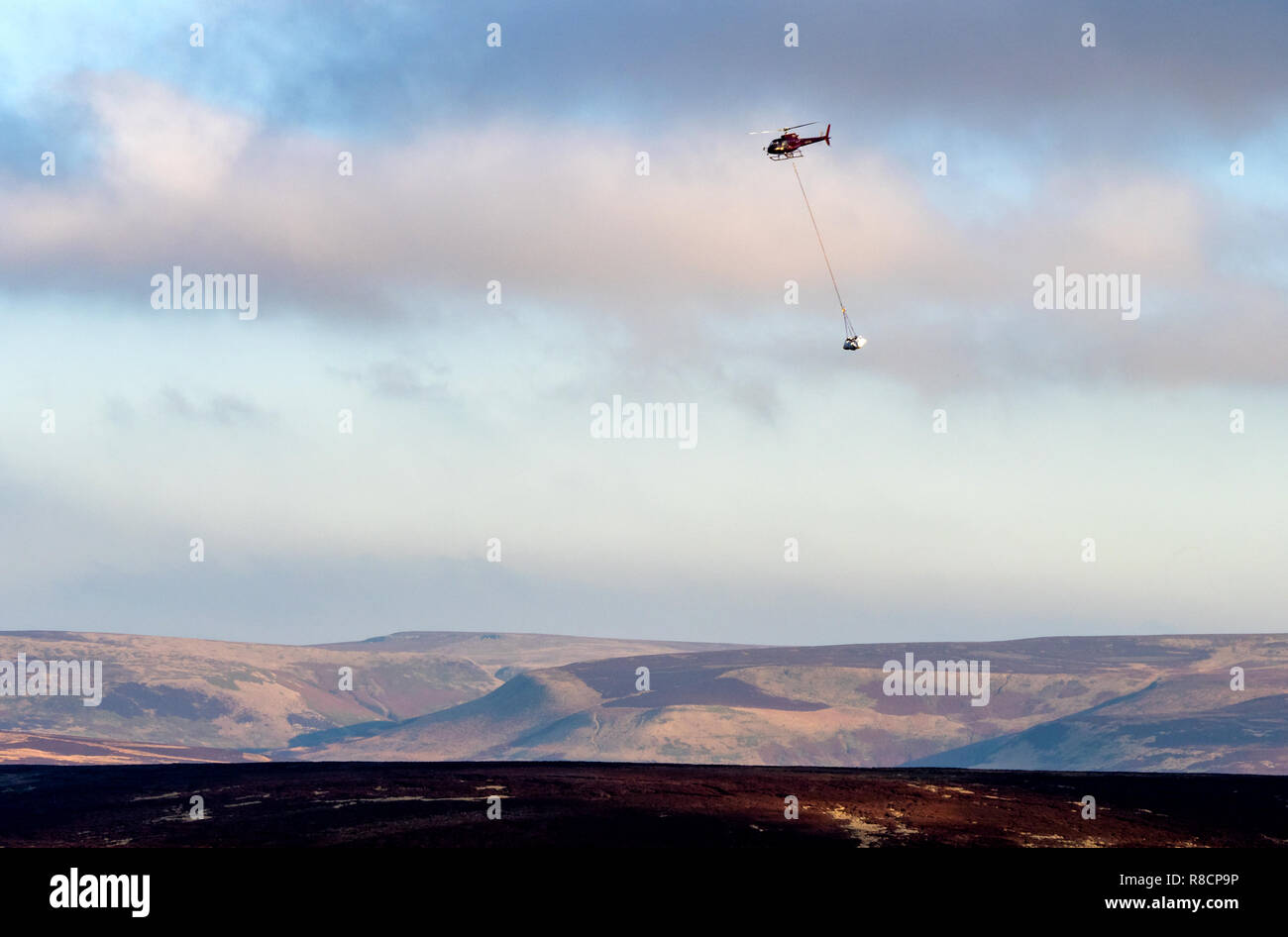 Elicottero pesante commovente di lastre di roccia Sentiero per controllo di erosione su Alport Moor nel Derbyshire Peak District Foto Stock