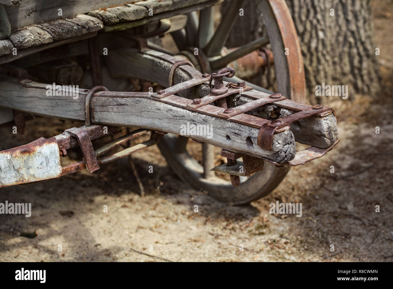 Chiusura del vecchio arrugginito carro in legno del meccanismo di collegamento della ruota, visibile in background Foto Stock